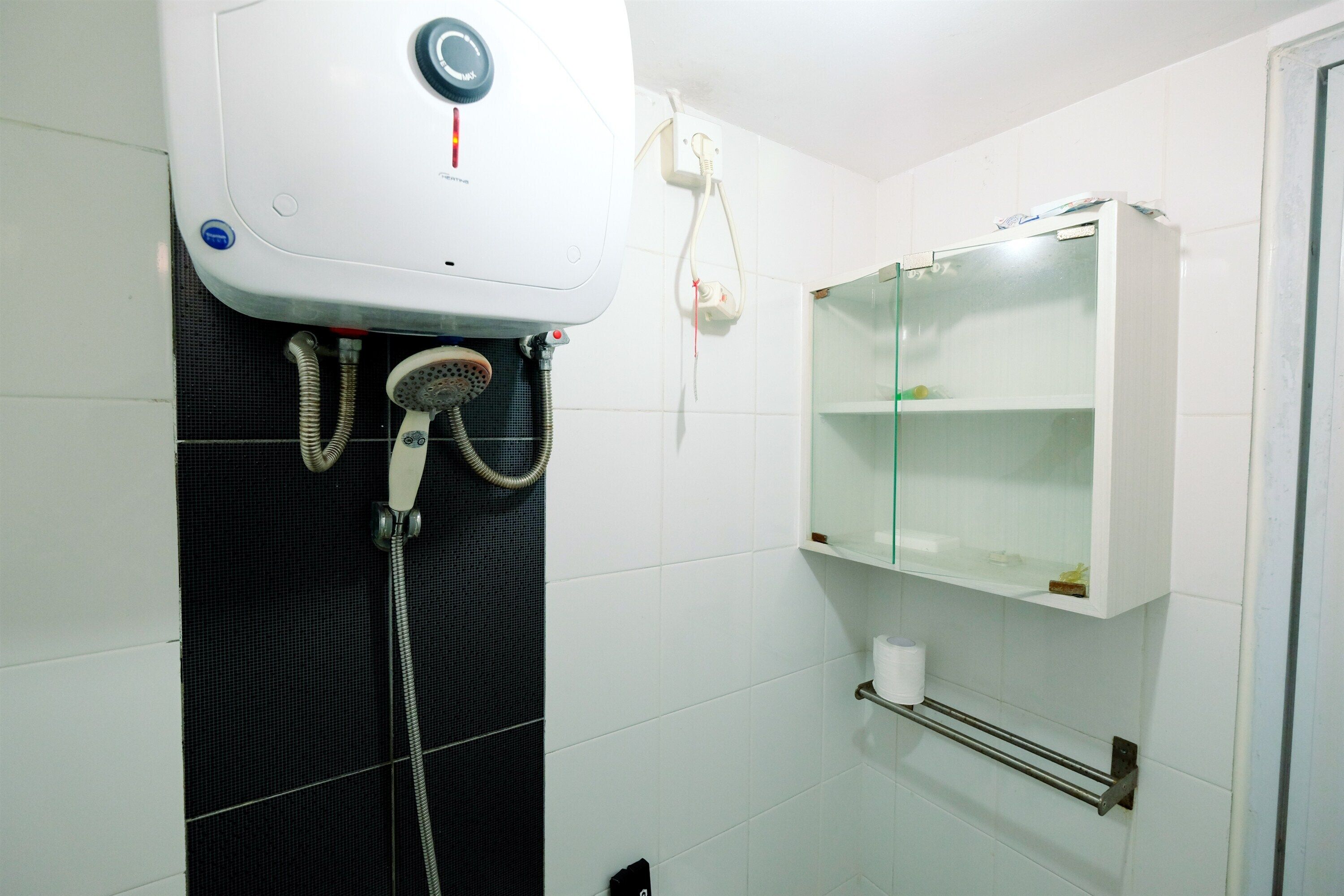 A bathroom with a shower, a toilet paper holder, and a medicine cabinet.