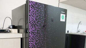 A black refrigerator with a purple geometric pattern, a white countertop, and a kitchen sink. - Modern City View Studio Apartment at Tuscany Residences (South Tangerang)