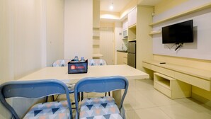 Une cuisine moderne avec un coin repas, un téléviseur à écran plat et un centre de table sur le thème du voyage.