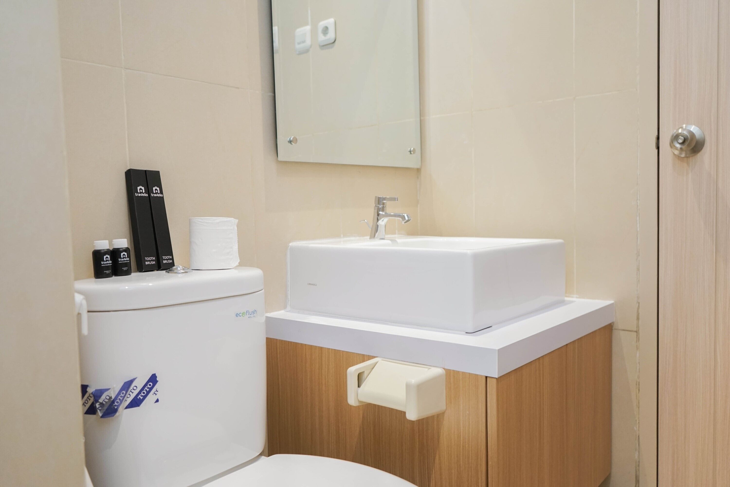A modern bathroom with a toilet, a sink, and a mirror.