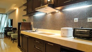 Una cocina moderna con armarios de madera oscura, un salpicadero de azulejos, un horno integrado y un tostador.
