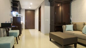 Una sala moderna con sofá, reposapiés y un comedor con mesa y sillas.