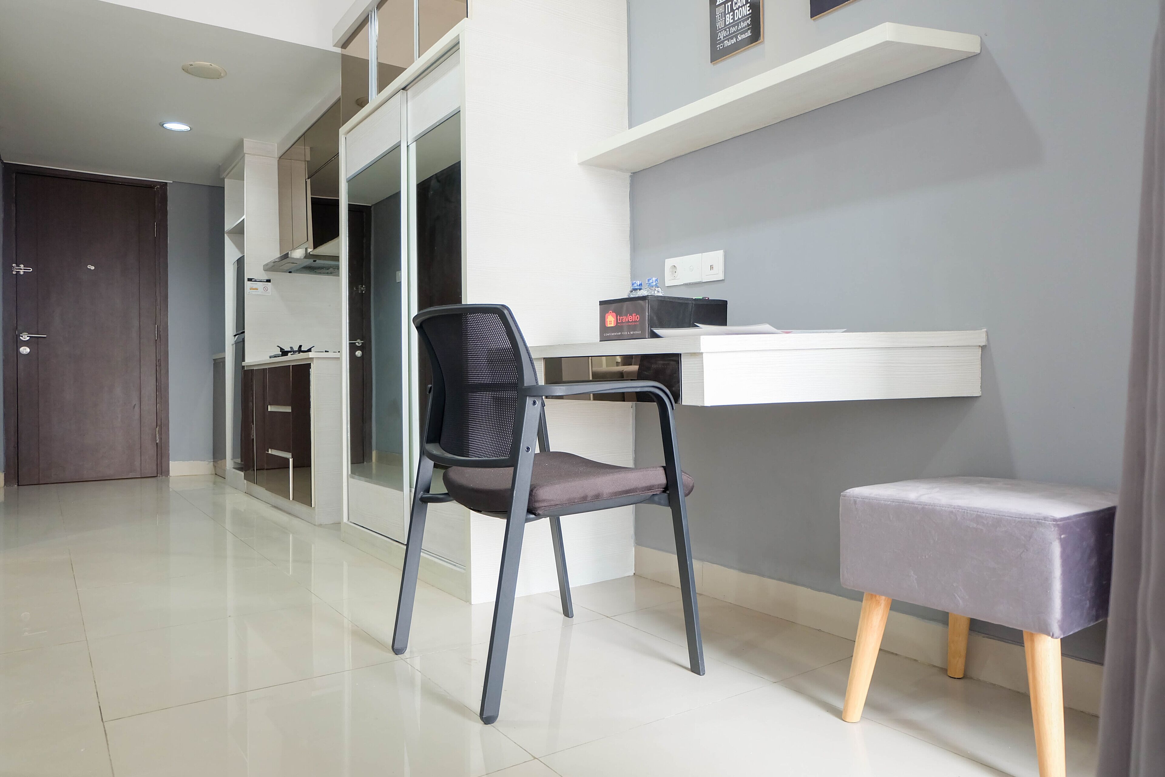 Une cuisine moderne équipée d’une cuisinière intégrée, d’une chaise et d’un petit tabouret.