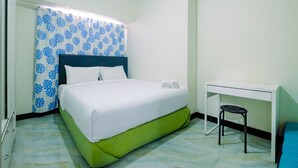 A neatly arranged bedroom with a bed, a desk, and a chair.