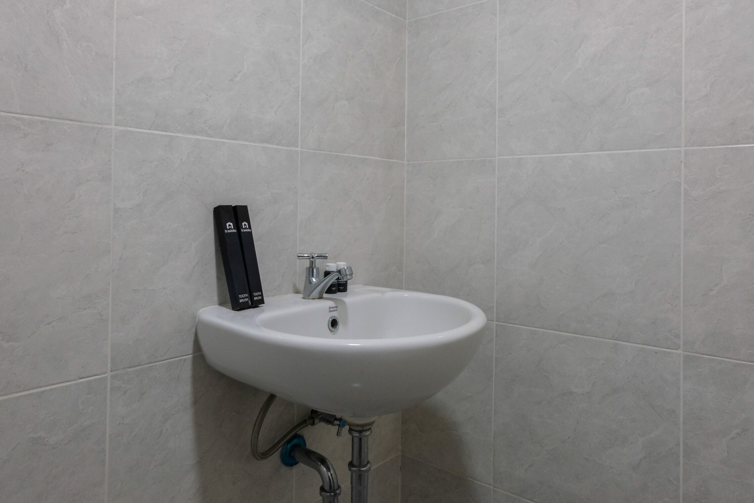 Un lavandino bianco con un rubinetto e un erogatore di sapone montato a parete.