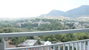A balcony with a view of a town and mountains. - Classic Studio Room Taman Melati Apartment Jatinangor near UNPAD (Hegarmanah)