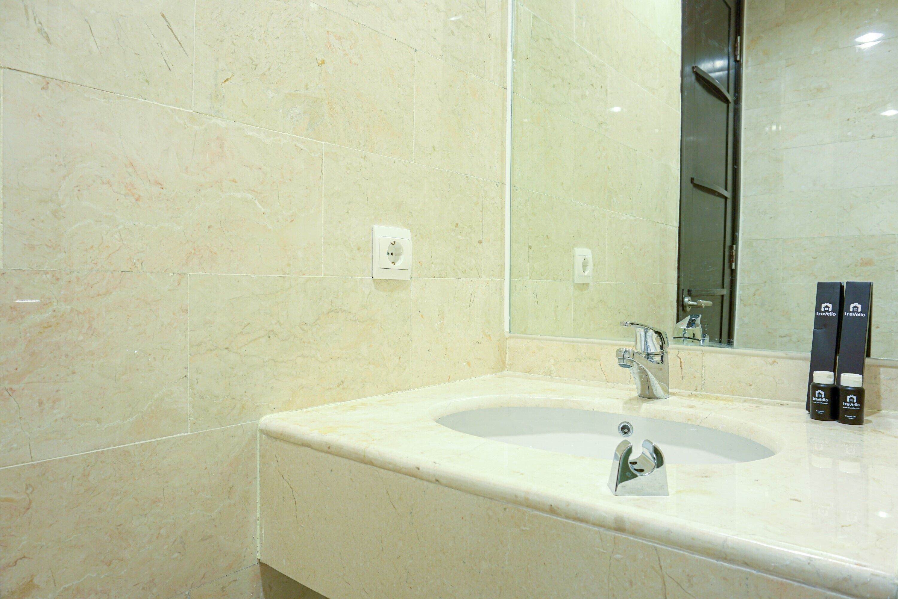 A bathroom with a sink, mirror, and toiletries.