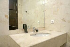 A bathroom with a marble sink, a mirror, and a hand dryer. - Cozy 2BR @ The Empyreal Condominium Epicentrum Apartment (Jakarta)