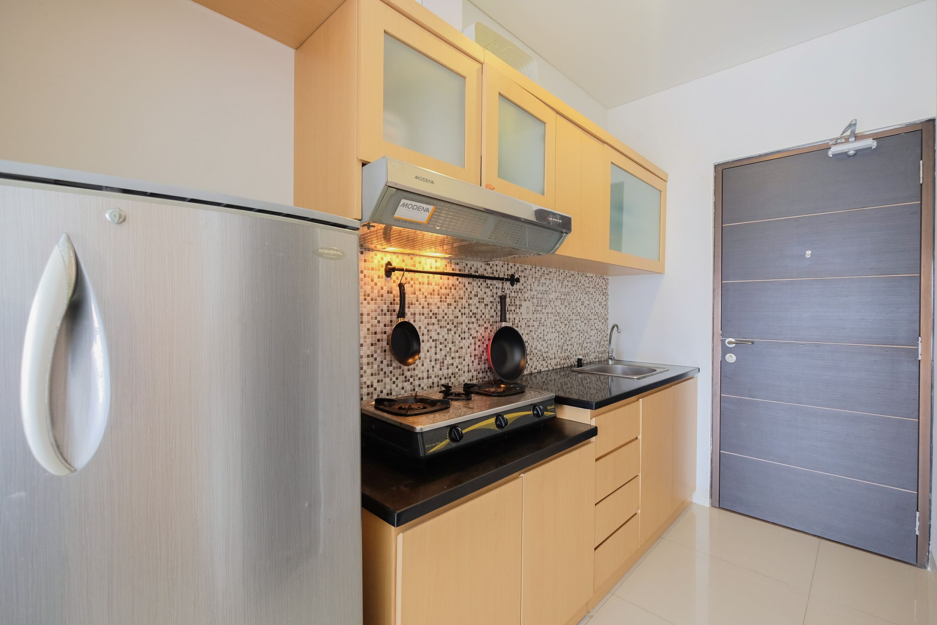 A modern kitchen with stainless steel appliances, wooden cabinets, and a tiled backsplash.