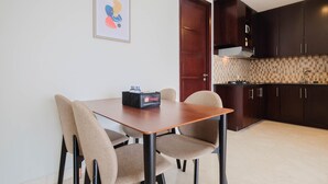 Una cocina moderna con armarios oscuros, salpicadero de azulejos y una mesa de comedor de madera con sillas.