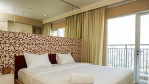 Habitación de hotel con una cama grande, una mesita de noche, un espejo y vistas a la ciudad desde la ventana.