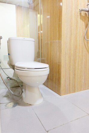 A modern bathroom with a white toilet, a shower area, and a marble wall. - Highest Value Studio Apartment at Parkland Avenue (South Tangerang)