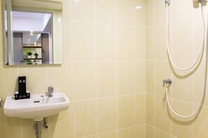 A bathroom with a sink, mirror, and shower. - Warm and Cozy 3BR Apartment at M-Town Residence (Gading Serpong)