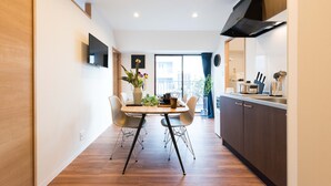Une cuisine moderne avec une table à manger, des chaises et une vue sur l’extérieur.