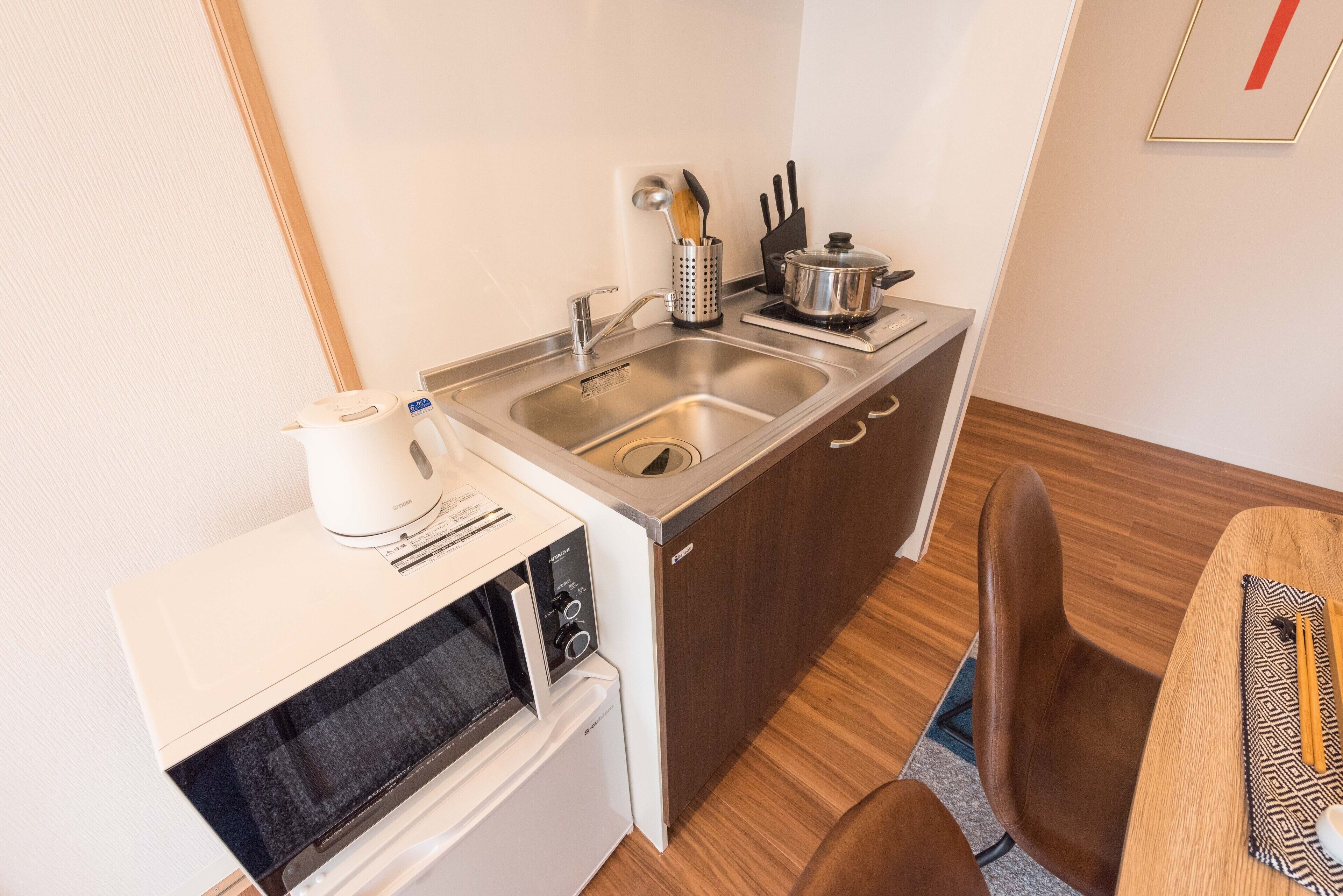 A compact kitchenette with a sink, microwave, and small oven.