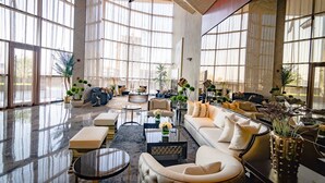 Un espace de vie spacieux et bien éclairé, doté de grandes fenêtres, de sièges confortables et de plantes décoratives.