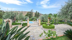 A landscaped garden with a swimming pool, stone pathways, and various plants. - Nice home in Trabia with private swimming pool, can be inside or outside (Trabia)