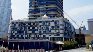 Un bâtiment moderne et imposant, doté d’une façade incurvée et arborant une combinaison de couleurs bleue et blanche.
