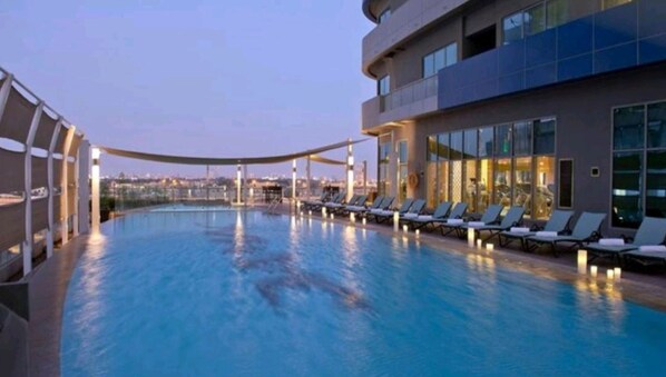 Een buitenzwembad, parasols voor strand/zwembad