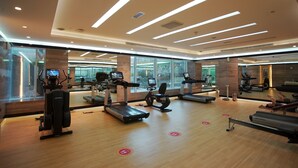 Un gimnasio moderno con cintas de correr, elípticas y bancos de pesas.