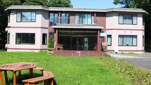 A two-story building with a flat roof, large windows, and a small front porch. - Pension Shadow Classe (Otaru)