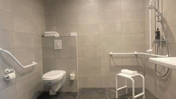 Une salle de bain moderne équipée de toilettes, d’un bidet et d’un espace douche.