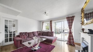 A living room with a sectional sofa, a glass coffee table, and a fireplace. - House - Sleeps 8 & On-site Parking (Aylesford)