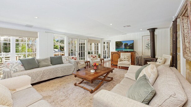A spacious living room with a large sofa set, a wooden coffee table, and a television. - Aylmerton House + Cottage for 14, Southern Highlands (Mittagong)