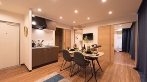 Una cocina moderna con armarios de madera, una estufa integrada y un comedor con una mesa redonda y cuatro sillas.