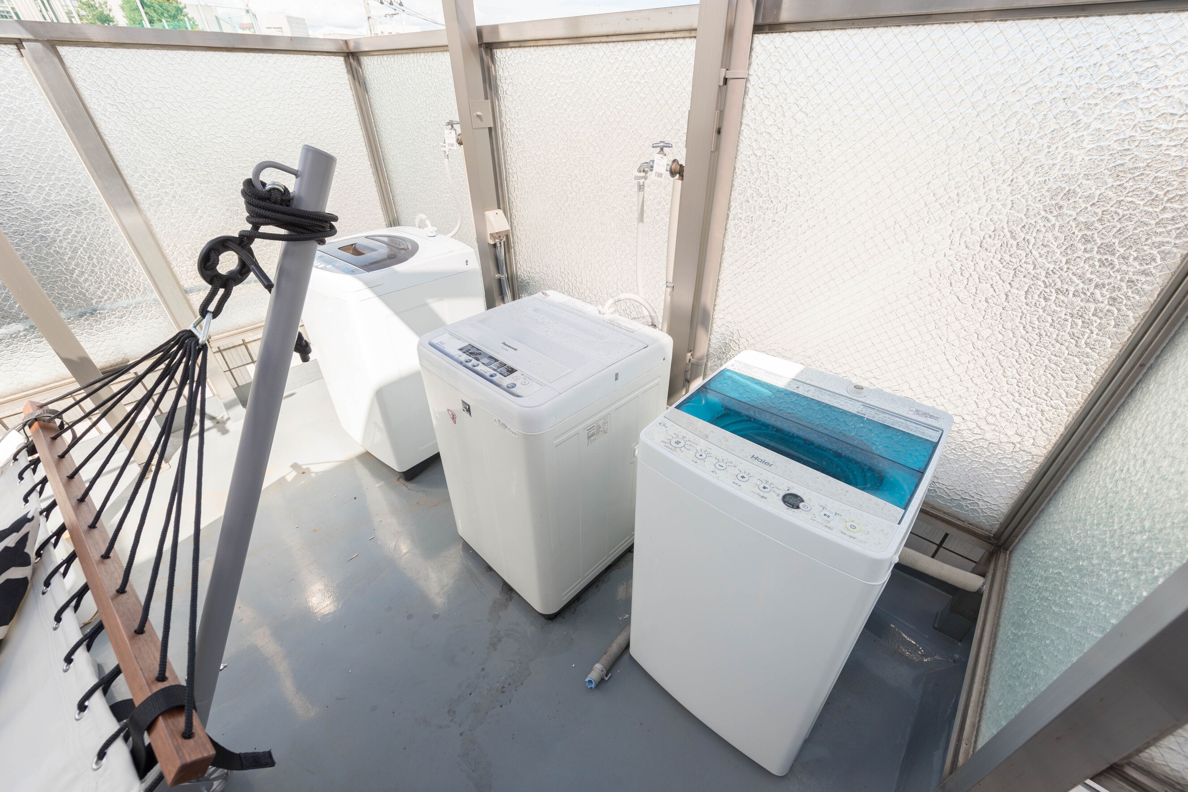 A laundry area with two washing machines and a drying rack.