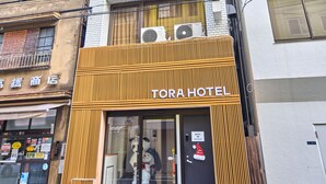 A hotel with a modern facade, a visible sign for the Torah Hotel, and a clear view of the entrance. - TORA Hotel Ueno 193D (Tokyo)