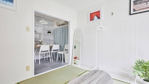 A modern room with a dining area, a large mirror, and a potted plant. - TORA Hotel Kita Ueno144 (Tokyo)