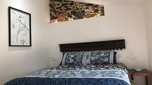 A bedroom with a bed, a headboard, a nightstand, a lamp, and a wall art piece. - Château du Parc Soubise - Gîte Parthenay l'Archevêque (Mouchamps)
