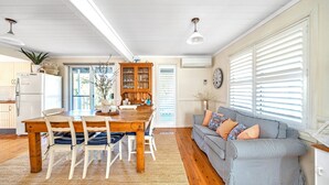 A spacious kitchen with a wooden dining table, chairs, and a built-in cabinet.