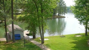 A lakeside property with a dock, a small shed, and a well-maintained lawn. - Beautiful Lake Front in Quiet Cove, Convenient to Boat Ramp, Dining & Shopping (Henrico)