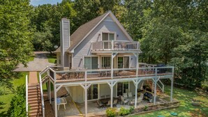 A two-story house with a balcony, outdoor seating area, and a covered patio. - Beautiful Lake Front in Quiet Cove, Convenient to Boat Ramp, Dining & Shopping (Henrico)