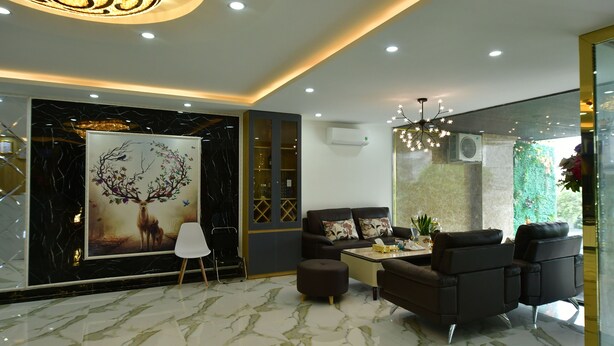 A modern living room with a marble floor, a large painting of a tree, and a chandelier. - Danang Lee's Studio Apartment near dragon bridge (Đà Nẵng)