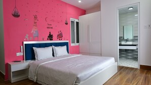 A bedroom with a bed, nightstand, wardrobe, and a bathroom visible through an open door. - Danang Lee's Studio Apartment near dragon bridge (Đà Nẵng)