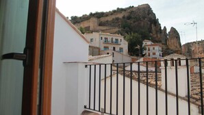 A view of a residential area with buildings and a rocky hill in the background. - Alojamiento con terraza en Chulilla (Chulilla)