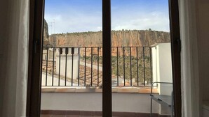A balcony with a view of a rocky landscape and a building in the distance. - Alojamiento con terraza en Chulilla (Chulilla)