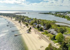 A coastal area with a beach, docks, and residential houses.
