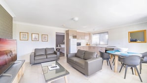 A modern apartment with a living room, dining area, and kitchen. - Sandals at the Bay - Downstairs, Hyams Beach (Hyams Beach)