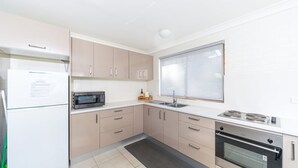 A modern kitchen with a refrigerator, microwave, sink, stove, and oven. - Sandals at the Bay - Downstairs, Hyams Beach (Hyams Beach)