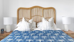A bed with a blue patterned bedspread, white pillows, and a wooden headboard. - Sandals at the Bay - Upstairs sleeps 6, Hyams Beach (Hyams Beach)