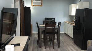 A compact kitchen with a dining area, wooden flooring, and a ceiling fan. - The Cottage at Sunset View Estate.  Close to rafting, hiking, Dollywood 30 mins. (Cosby)