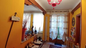 Ein gemütliches Wohnzimmer mit einer Chandelüster, einem Schild mit der Aufschrift "AMICI E FAMIGLIA" und einem Bücherregal.