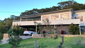 A modern two-story house with a covered garage and a car parked inside.