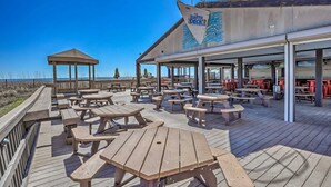 Een restaurant aan het strand met terras en uitzicht op de oceaan.