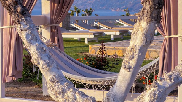 A hammock tied between trees, a view of a pool area with lounge chairs, and a mountainous landscape in the background. - Traditional Fully Private Villa with Pool (Chania)