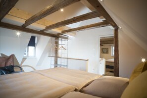 Ein Schlafzimmer mit Hochbett, Holzboden und einem Regal aus Metall sowie einem Fenster.
